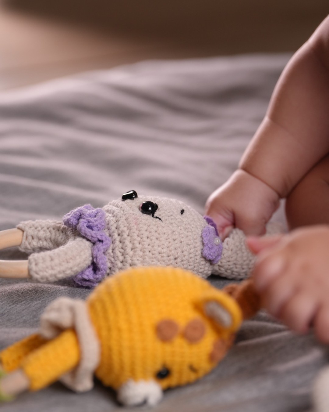 Baby reaching for crochet teether toys