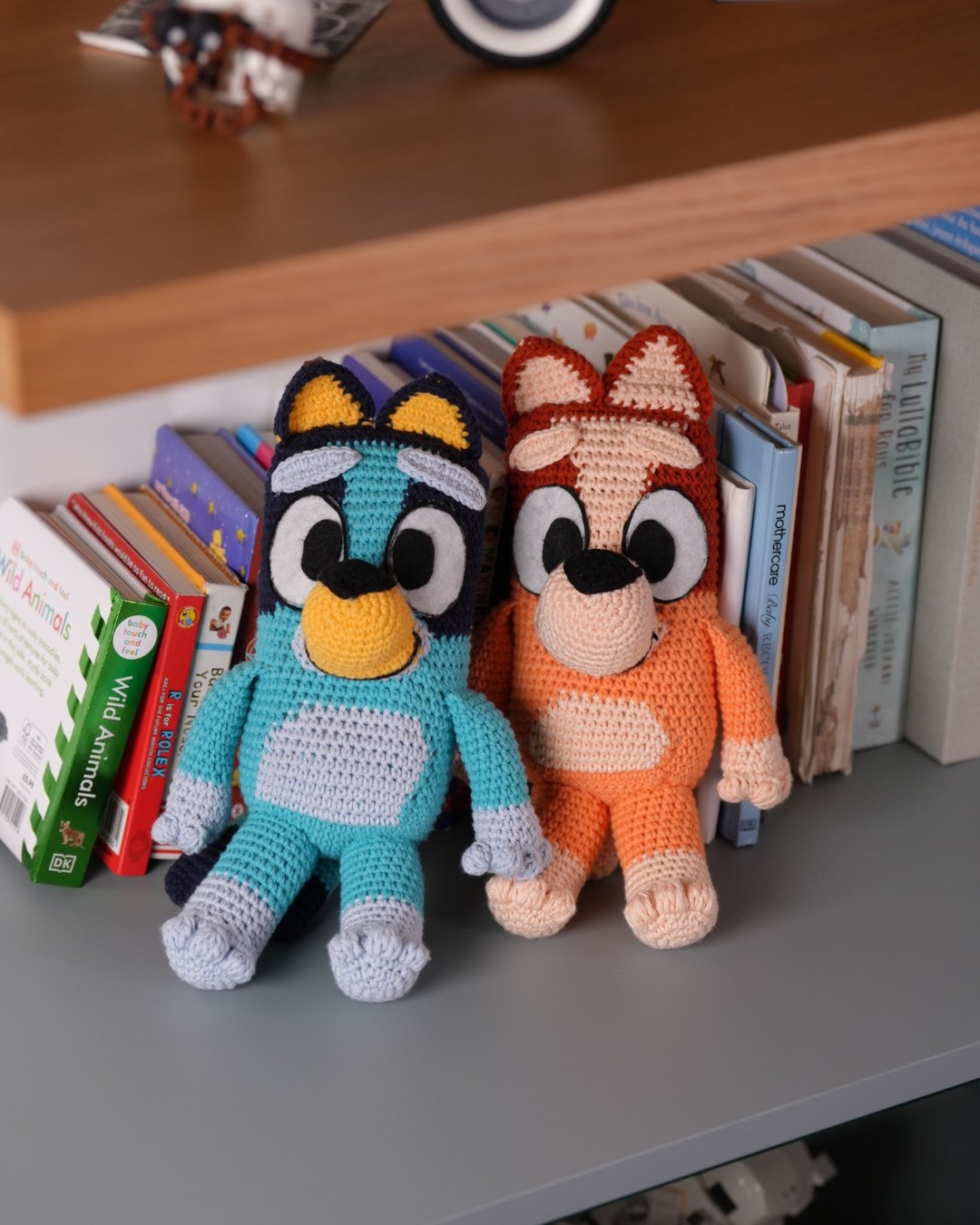 Handmade crochet Bluey and Bingo looking at the camera